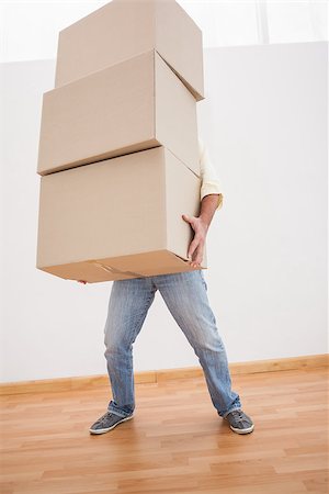 simsearch:400-07928013,k - Man balancing heavy cardboard boxes at home in the living room Fotografie stock - Microstock e Abbonamento, Codice: 400-07927838