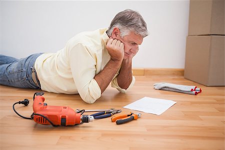 simsearch:400-07931092,k - Man lying on floor reading tool instructions at home in the living room Foto de stock - Super Valor sin royalties y Suscripción, Código: 400-07927832