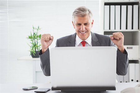 simsearch:400-07927898,k - Cheering businessman at his desk in his office Stock Photo - Budget Royalty-Free & Subscription, Code: 400-07927883