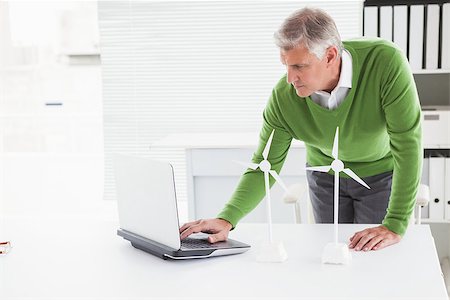 Casual businessman looking at model wind turbines  in his office Stock Photo - Budget Royalty-Free & Subscription, Code: 400-07927922