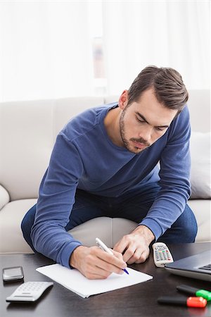 simsearch:6109-07601407,k - Young man paying his bills at home in the living room Photographie de stock - Aubaine LD & Abonnement, Code: 400-07927937