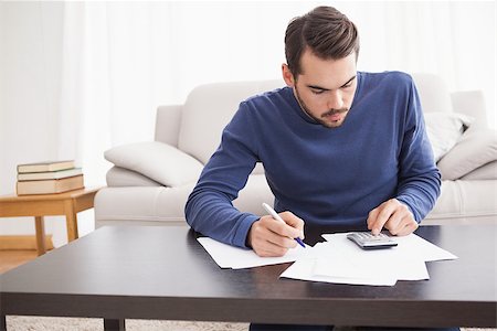 simsearch:6109-08390207,k - Young man paying his bills at home in the living room Foto de stock - Super Valor sin royalties y Suscripción, Código: 400-07927939