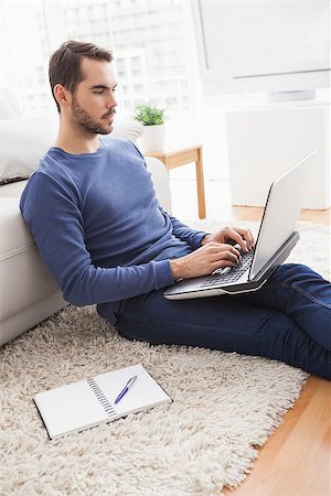 simsearch:6109-08581996,k - Young man sitting on floor using laptop at home in the living room Fotografie stock - Microstock e Abbonamento, Codice: 400-07927947