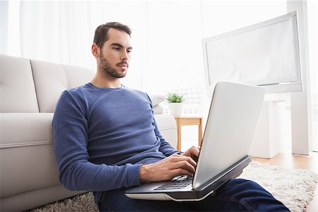 simsearch:6109-08581996,k - Young man sitting on floor using laptop at home in the living room Fotografie stock - Microstock e Abbonamento, Codice: 400-07927948