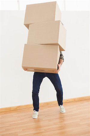 simsearch:400-07928013,k - Man balancing heavy cardboard boxes at home in the living room Fotografie stock - Microstock e Abbonamento, Codice: 400-07928005