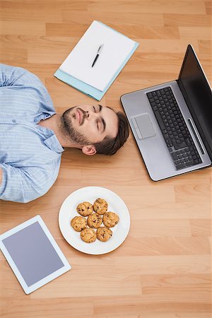 simsearch:400-07931092,k - Casual man lying on floor surrounded by his possesions at home in the living room Foto de stock - Super Valor sin royalties y Suscripción, Código: 400-07928018