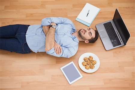 simsearch:400-07931092,k - Casual man lying on floor surrounded by his possesions at home in the living room Foto de stock - Super Valor sin royalties y Suscripción, Código: 400-07928019