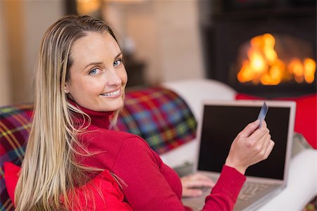 simsearch:400-07474252,k - Smiling blonde shopping online with laptop at christmas at home in the living room Stock Photo - Budget Royalty-Free & Subscription, Code: 400-07928107