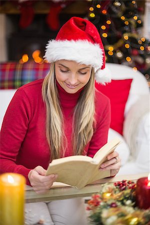 simsearch:6109-06194272,k - Pretty blonde in santa hat reading book at christmas time at home in the living room Stock Photo - Budget Royalty-Free & Subscription, Code: 400-07928112