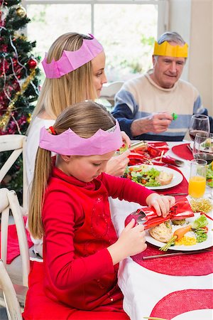 senior woman at christmas parties - Little girl in party hat holding christmas crackers at home in the living room Stock Photo - Budget Royalty-Free & Subscription, Code: 400-07928308