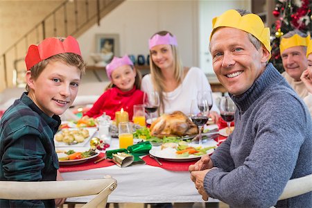 simsearch:400-07928326,k - Smiling extended family in party hat at dinner table at home in the living room Photographie de stock - Aubaine LD & Abonnement, Code: 400-07928314