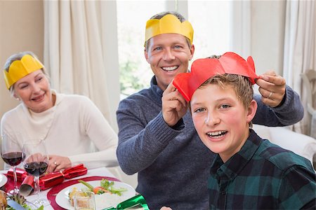 senior woman at christmas parties - Smiling father putting party hat on sons head at home in the living room Stock Photo - Budget Royalty-Free & Subscription, Code: 400-07928311