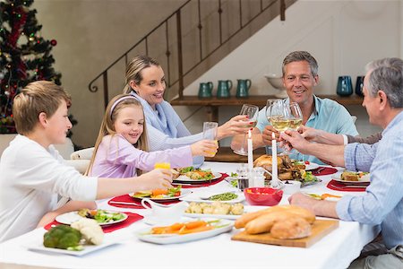 simsearch:400-07928326,k - Family toasting with white wine in a christmas dinner at home in the living room Photographie de stock - Aubaine LD & Abonnement, Code: 400-07928354