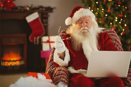 Santa claus using laptop on the armchair at home in the living room Stock Photo - Budget Royalty-Free & Subscription, Code: 400-07928597