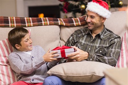 simsearch:6109-07601570,k - Son giving father a christmas gift on the couch at home in the living room Stockbilder - Microstock & Abonnement, Bildnummer: 400-07928726