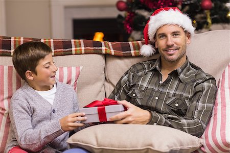 simsearch:6109-07601570,k - Son giving father a christmas gift on the couch at home in the living room Stockbilder - Microstock & Abonnement, Bildnummer: 400-07928727