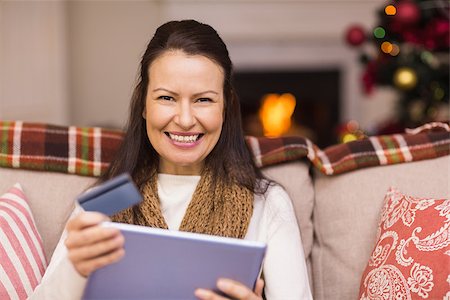 simsearch:400-07474252,k - Brunette shopping online with laptop at christmas at home in the living room Stock Photo - Budget Royalty-Free & Subscription, Code: 400-07928737