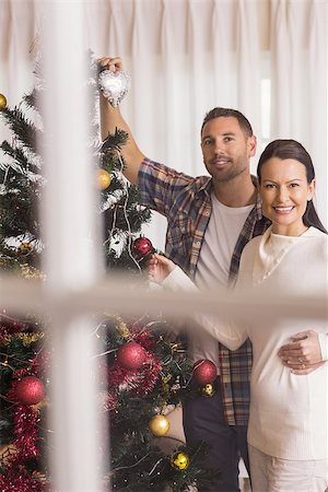 simsearch:400-07931092,k - Smiling couple decorating the christmas tree together at home in the living room Foto de stock - Super Valor sin royalties y Suscripción, Código: 400-07928815