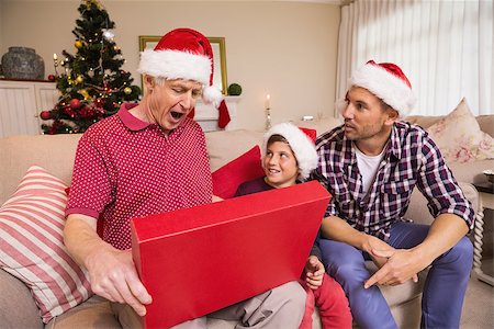 simsearch:400-07929054,k - Surprised grandfather opening his gift at home in the living room Stock Photo - Budget Royalty-Free & Subscription, Code: 400-07928881