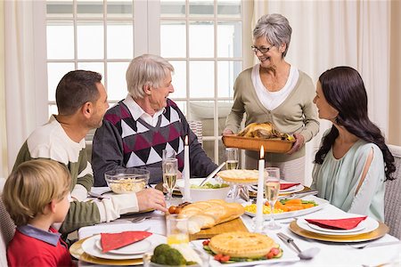 simsearch:400-06871551,k - Grandmother holding turkey roast with family at dining table at home in the living room Stock Photo - Budget Royalty-Free & Subscription, Code: 400-07928911
