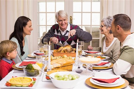 simsearch:400-07928326,k - Grandfather carving chicken during christmas dinner at home in the living room Photographie de stock - Aubaine LD & Abonnement, Code: 400-07928920