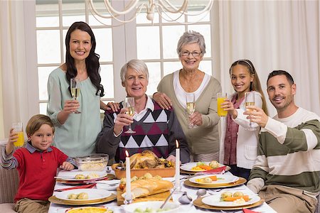 simsearch:400-07928326,k - Happy extended family at christmas toasting at camera at home in the living room Photographie de stock - Aubaine LD & Abonnement, Code: 400-07928958