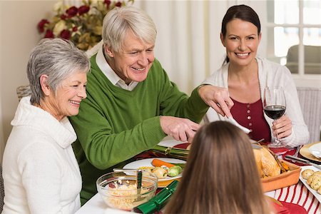 simsearch:400-07929054,k - Smiling grandfather carving chicken during christmas dinner at home in the living room Stock Photo - Budget Royalty-Free & Subscription, Code: 400-07928991