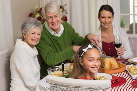 simsearch:400-07929054,k - Smiling grandfather carving chicken during christmas dinner at home in the living room Stock Photo - Budget Royalty-Free & Subscription, Code: 400-07928992