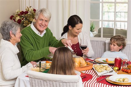 simsearch:400-07928326,k - Happy grandfather carving chicken during christmas dinner at home in the living room Photographie de stock - Aubaine LD & Abonnement, Code: 400-07928993