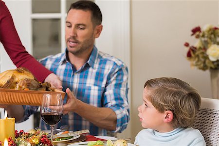 simsearch:400-07928326,k - Woman passing the roast turkey to her husband at home in the living room Photographie de stock - Aubaine LD & Abonnement, Code: 400-07929007