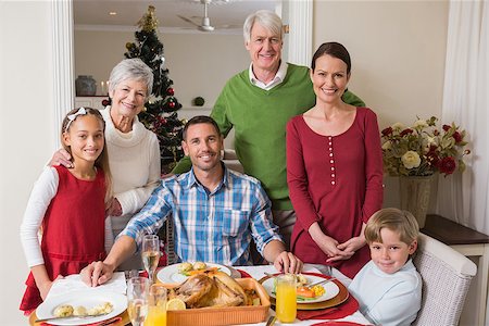 simsearch:400-07929054,k - Smiling extended family looking at camera at christmas time at home in the living room Stock Photo - Budget Royalty-Free & Subscription, Code: 400-07929036