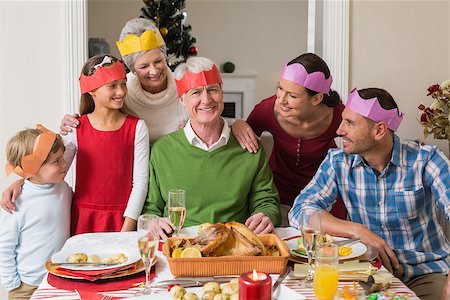 simsearch:400-07929054,k - Happy extended family in party hat at dinner table at home in the living room Stock Photo - Budget Royalty-Free & Subscription, Code: 400-07929059