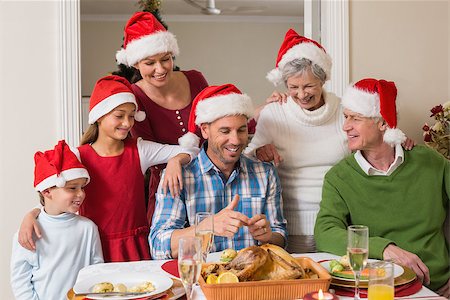 simsearch:400-07928327,k - Happy extended family in santa hat at christmas dinner at home in the living room Foto de stock - Super Valor sin royalties y Suscripción, Código: 400-07929062
