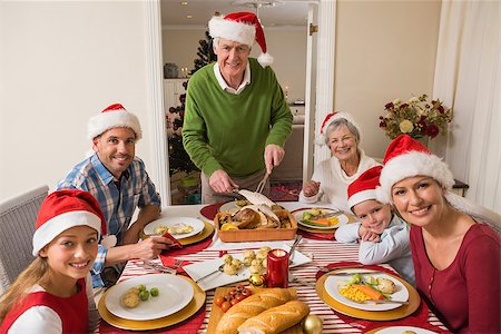 simsearch:400-06871551,k - Grandfather in santa hat carving roast turkey at christmas dinner at home in the living room Stock Photo - Budget Royalty-Free & Subscription, Code: 400-07929074