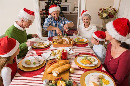simsearch:400-06871551,k - Father in santa hat carving roast turkey at christmas at home in the living room Stock Photo - Budget Royalty-Free & Subscription, Code: 400-07929077