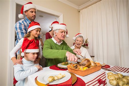 simsearch:400-07929054,k - Grandfather in santa hat carving chicken at christmas at home in the living room Stock Photo - Budget Royalty-Free & Subscription, Code: 400-07929070