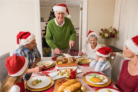 simsearch:400-06871551,k - Grandfather in santa hat carving roast turkey at christmas at home in the living room Stock Photo - Budget Royalty-Free & Subscription, Code: 400-07929073
