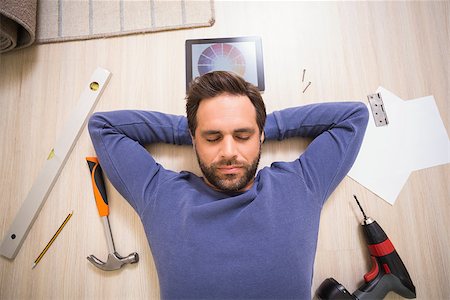 simsearch:400-07931092,k - Casual man lying on floor surrounded by his diy tools at home in the living room Foto de stock - Super Valor sin royalties y Suscripción, Código: 400-07929296