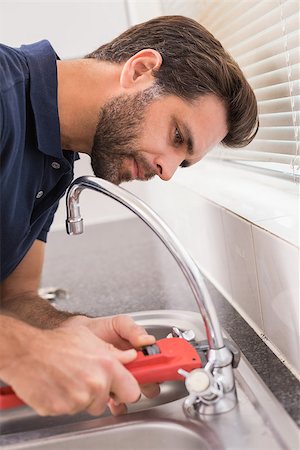 simsearch:400-07929795,k - Man fixing tap with tool in the kitchen Stock Photo - Budget Royalty-Free & Subscription, Code: 400-07929355