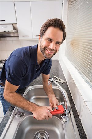 simsearch:400-07929795,k - Man fixing tap with tool in the kitchen Stock Photo - Budget Royalty-Free & Subscription, Code: 400-07929356