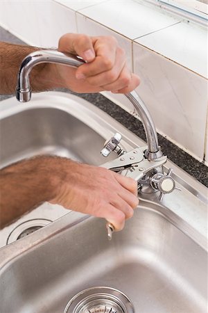 simsearch:400-07929795,k - Man fixing tap with pliers at home in the kitchen Stock Photo - Budget Royalty-Free & Subscription, Code: 400-07929351