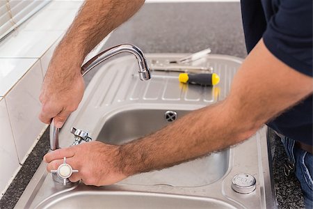 simsearch:400-07929795,k - Man fixing tap with pliers in the kitchen Stock Photo - Budget Royalty-Free & Subscription, Code: 400-07929352