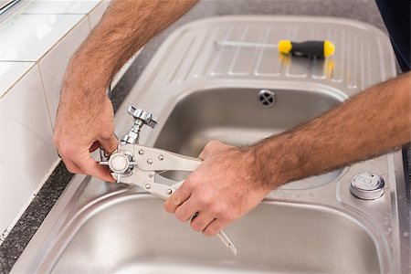 simsearch:400-07929361,k - Man fixing tap with pliers in the kitchen Stockbilder - Microstock & Abonnement, Bildnummer: 400-07929353