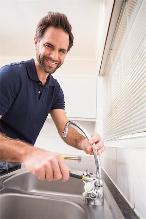 simsearch:400-07929361,k - Plumber fixing the sink with wrench in the kitchen Stockbilder - Microstock & Abonnement, Bildnummer: 400-07929374