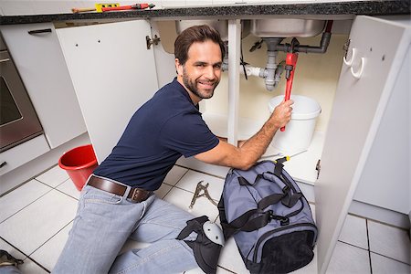 simsearch:400-07929795,k - Plumber fixing under the sink in the kitchen Stock Photo - Budget Royalty-Free & Subscription, Code: 400-07929371