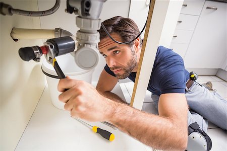 simsearch:400-07929361,k - Plumber fixing under the sink in the kitchen Stockbilder - Microstock & Abonnement, Bildnummer: 400-07929386