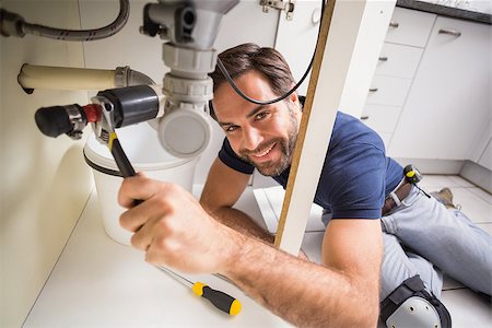simsearch:400-07929795,k - Plumber fixing under the sink in the kitchen Stock Photo - Budget Royalty-Free & Subscription, Code: 400-07929387