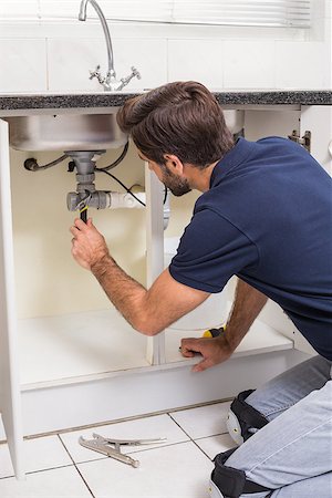simsearch:400-07929361,k - Plumber fixing under the sink in the kitchen Stockbilder - Microstock & Abonnement, Bildnummer: 400-07929382