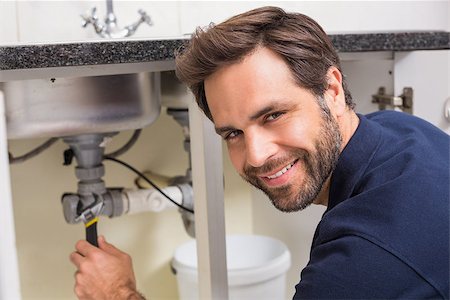simsearch:400-07929361,k - Plumber fixing under the sink in the kitchen Stockbilder - Microstock & Abonnement, Bildnummer: 400-07929383