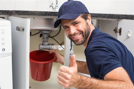 simsearch:400-07929361,k - Plumber fixing under the sink in the kitchen Stockbilder - Microstock & Abonnement, Bildnummer: 400-07929414